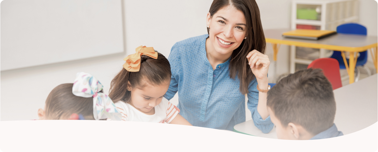 The kindergarten teacher is teaching children to draw