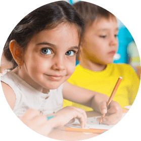 A girl in kindergarten is learning to write